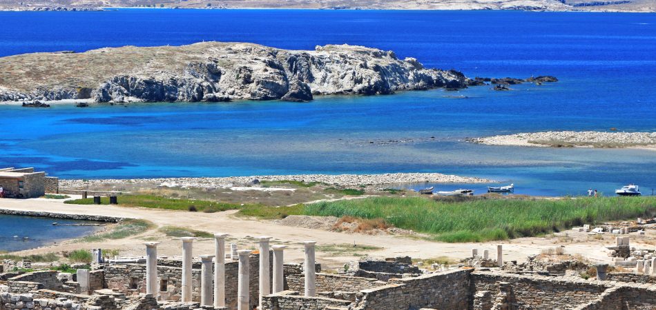 At the archaeological site of the sacred island of Delos. In the background Rineia island Cyclades Greece.